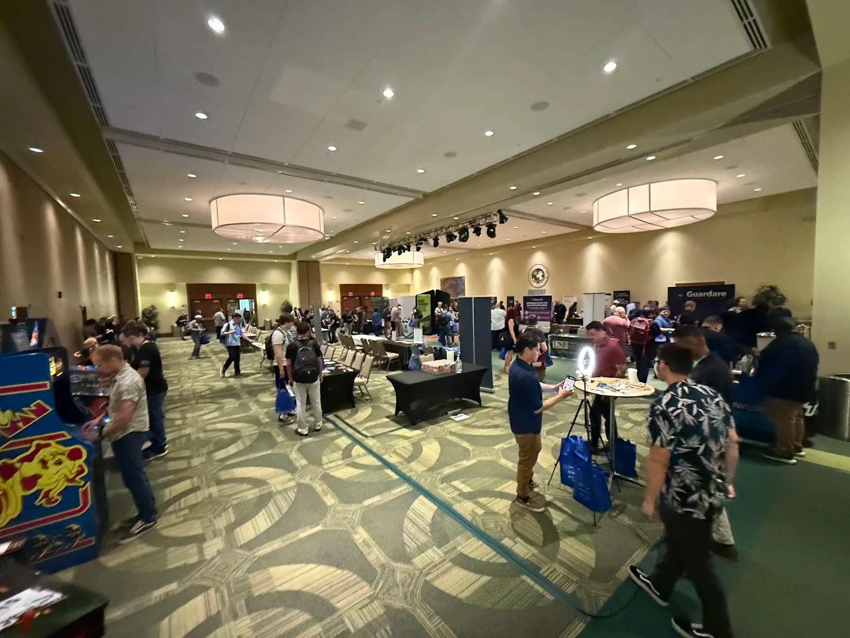 Expo hall with sponsor booths, energy and coffee stations, and participants browsing
